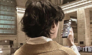 picture of the back of taehyung's head while he takes a video on his phone